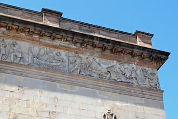 Entablature and Carved Stone Frieze on Stone Building seen from Below against Blue Sky 