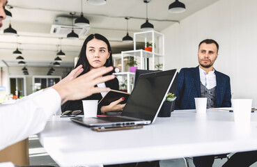 Group of young business people working and communicating while sitting at the office desk together with colleagues sitting. business meeting