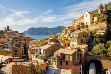 Fototapeta na wymiar Landscape of Vernazza village with colorful old houses and church on the hill at sunny day. Famous village at Cinque Terre National Park at coastline in northwestern of Italy