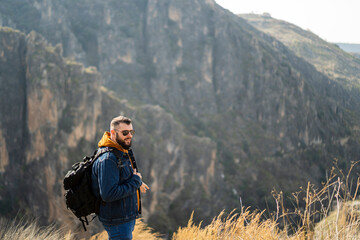 Chico alto con barba de senderismo por paraje natural en andalucia