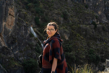 Naklejka premium Chica joven guapa con gafas en entorno natural tomando fotografías mientras esta de senderismo en un parque natural