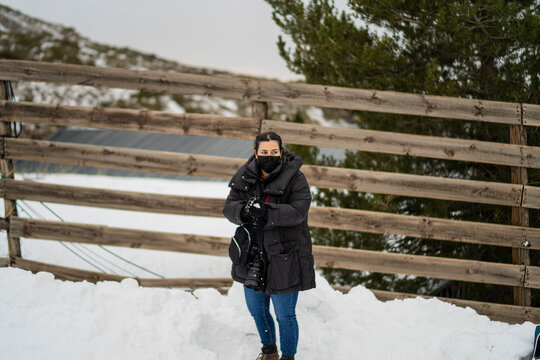 Chica joven guapa en la nieve posando feliz ante la c&aacute;mara y poniendo caras graciosas