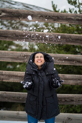 Chica joven guapa en la nieve posando feliz ante la cámara y poniendo caras graciosas