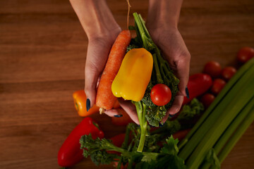 African American female cooking in kitchen holding fresh vegetables 