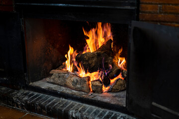 Chimenea encendida con fuego y madera chamuscada