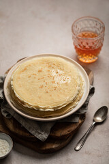 Assiette de crêpes empilées sur une table avec verre de cidre