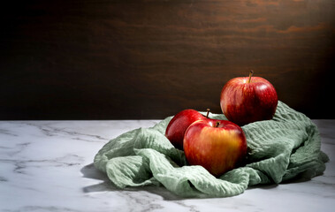 red apples on a marble table on a burlap napkin, low key