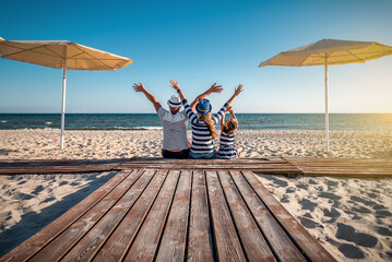 funny family in striped clothes at the beach