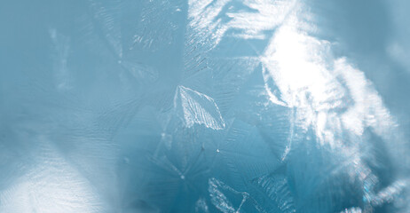 Texture of ice covered glass against blue background.