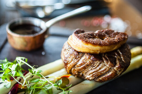 Tournedos Rossini. Foie gras, Black Angus beef tenderloin, white asparagus, red wine sauce. Delicious healthy traditional food closeup served for lunch in modern gourmet cuisine restaurant