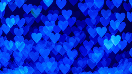 Bokeh background with blue hearts on black background. Love concept. Theme for Valentine's Day