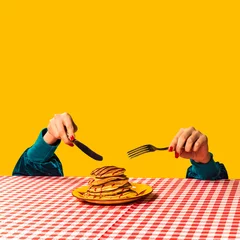 Poster Food pop art photography. Female hand and sweet pancakes on plaid tablecloth isolated on bright yellow background. Vintage, retro style © master1305