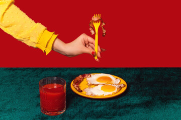 Human hand tasting bacon and eggs isolated on green and red background. Vintage, retro style...
