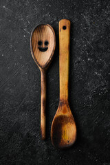 Old wooden kitchen spoon. Top view. On a stone background.