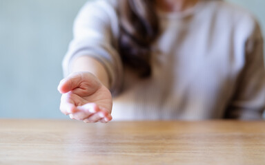 Closeup image of a woman reaching hand or giving hand to someone