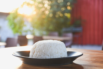 Plain rice on a black plate on the table