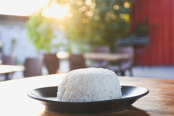 Plain rice on a black plate on the table