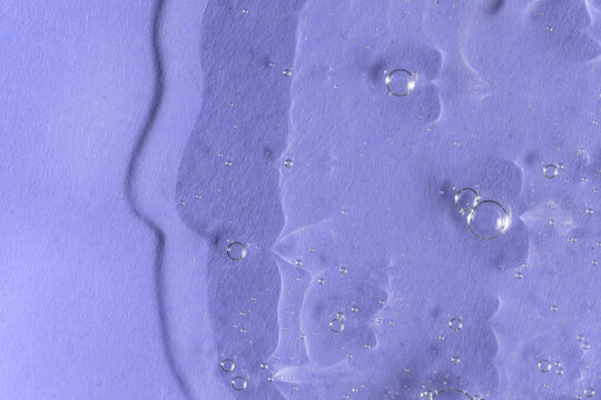 Textured backdrop with air bubbles. Gel, serum or hyaluronic acid on violet blue background. Cosmetics, beauty products presentation concept. Color of the year 2022. 