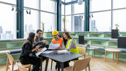 A group of construction engineers or real estate architectures from different genders and cultures have meeting with investor for a new development project in a green office with cityscape background