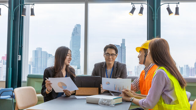 A group of construction engineers or real estate architectures from different genders and cultures have meeting with investor for a new development project in a green office with cityscape background