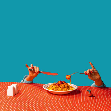 Naklejka Food pop art photography. Female hands tasting spaghetti with meatballs on plaid tablecloth isolated on bright blue background. Vintage, retro style interior