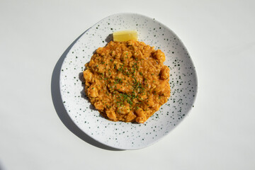 Prawns and beef pasta with doted plates served with a lemon slice