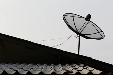 Foto op Plexiglas Silhouette of a satellite dish radio telescope antenna facing the sky to receive satellite signals. © pattanawit