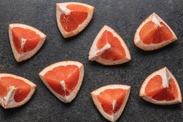 Sliced citrus fruit. Chopped fresh grapefruit on black table.