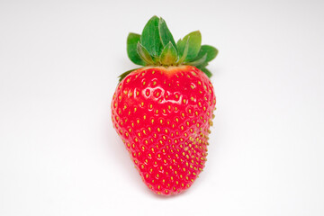 Whole strawberry berry with green leaf isolated on white background