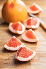 Sliced citrus fruit. Chopped fresh grapefruit on wooden table.