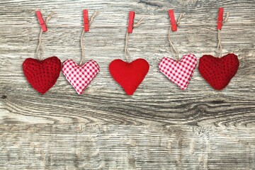 Hand made colored hearts over a wooden background