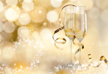 Two champagne flutes on beautiful gold shiny background