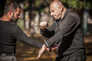 Knife vs knife fight. Kapap instructors demonstrates sombrada drill training