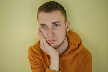 The guy in orange clothes with blue eyes is sad