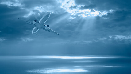 Airplane flying over tropical sea at sunset