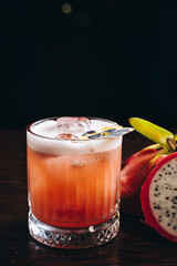 Glass of dragonfruit refresher drink on table with ice cubes. Pitahaya fruits