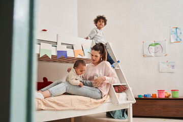 Caucasian woman sitting at the bed and holding her children at the laps