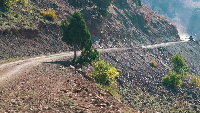 cars leave from behind the mountain and rush along the serpentine. Beautiful mountain landscape