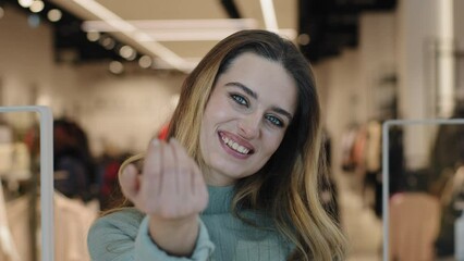 Portrait caucasian female shopper seductive smiling woman saleswoman owner of clothing store looking at camera making gesture hey you come here inviting waving hand offer discount tempting approaching