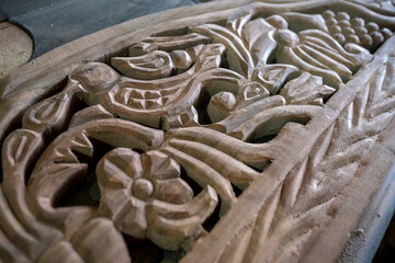 Carved bird and flower pattern on wooden background. traditional wood carving
