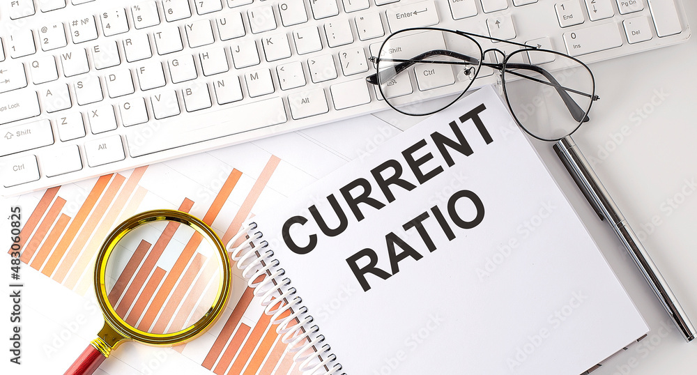 Poster current ratio text written on a notebook with keyboard, chart,and glasses