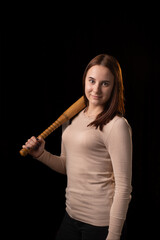 Young woman with a bat on a dark background. Self-defense, psychological protection, mental strength, inner peace concept.