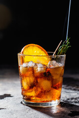 Cocktail with ice in a glass on a dark background