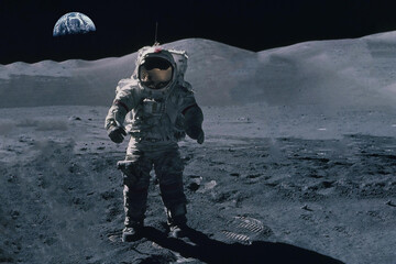 Astronaut on the moon, against the background of the Earth. Elements of this image were furnished...