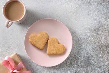 Obraz premium Valentine's Day breakfast with coffee, heart shaped cookies on pink plate on gray table. View from above. Copy space.
