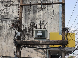 The old AC high-voltage power transformer on concrete pole changing high voltage to low voltage in...