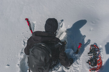 An unrecognizable male hiker who's fallen down waist-deep in the snow in the French Alps on a cold...