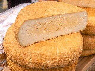 Homemade farm cheese made from natural cow's milk. Cheese made from cow's milk without chemical additives. Cheese on the market counter.