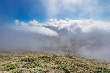 Clouds above the mountain meadow at autumn day.