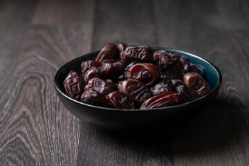Mix of dates and nuts in plate on a white wood background .healthy food